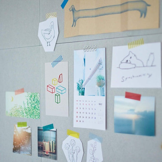 Collection of small prints and a calendar attached to a gray wall.