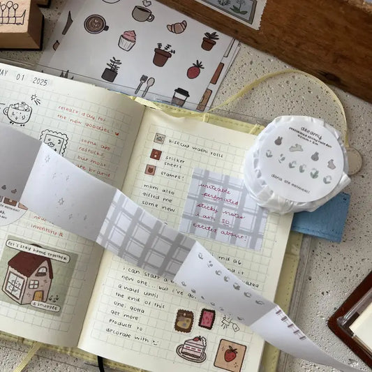 Open notebook with decorative stickers and a small round container on a textured surface.