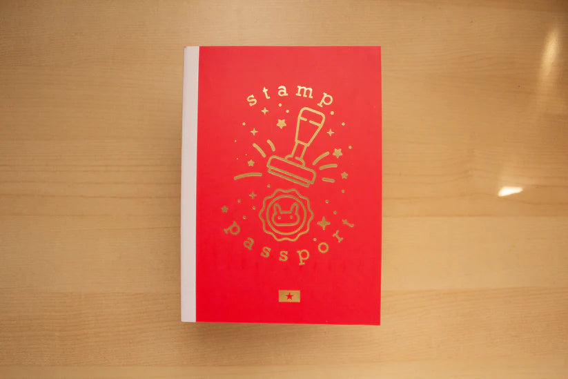 Red book with a stamp design on a wooden surface