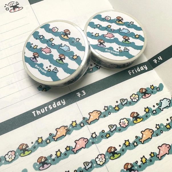 Two rolls of decorative tape with cartoon designs on a planner page.