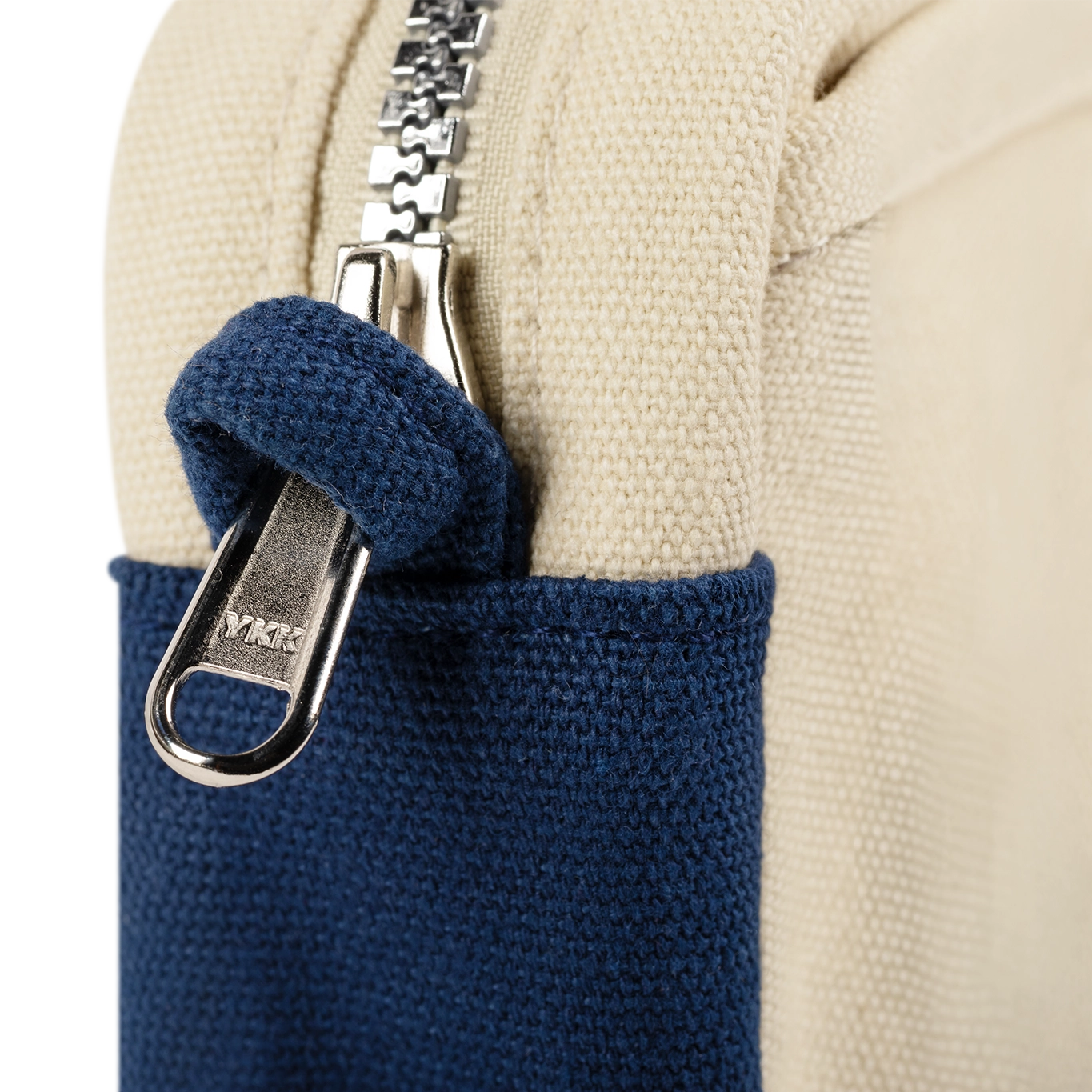 Close-up of a backpack with blue pocket and zipper, featuring the brand name 'Timbuk2'.