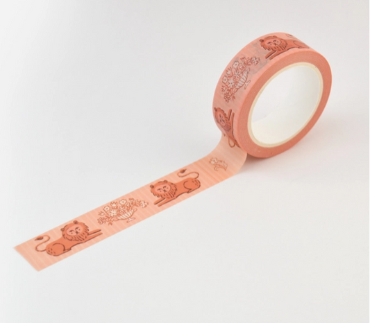 Roll of pink decorative tape with embossed designs on a light gray background
