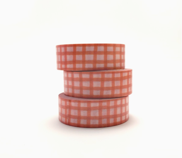 Three rolls of checkered tape stacked on a white background