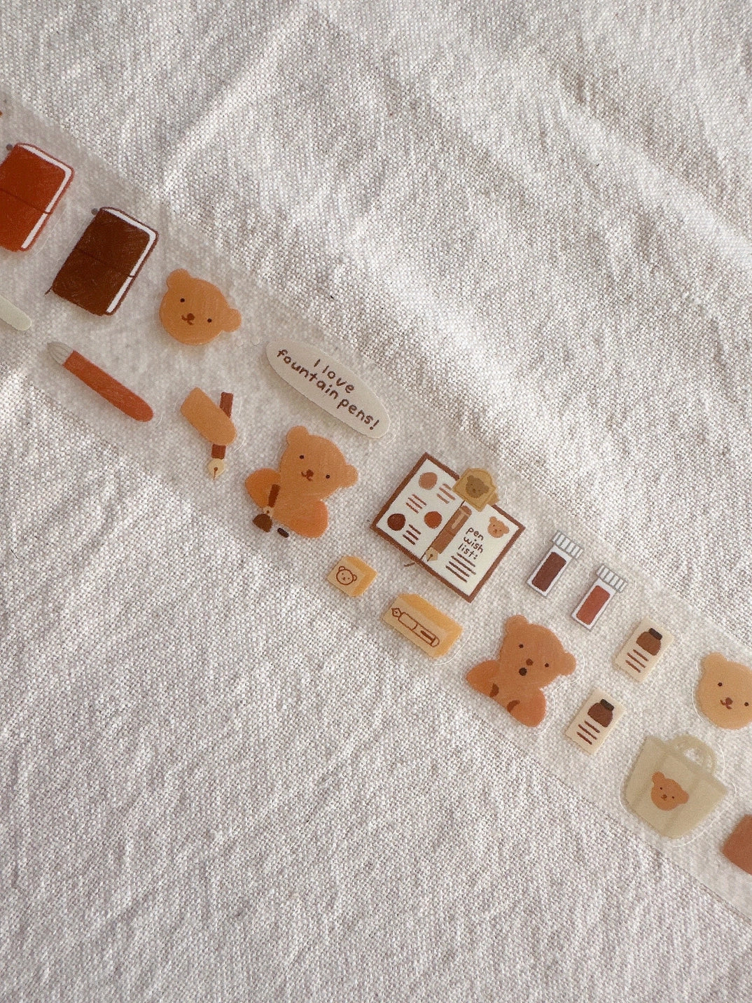 Decorative washi tape with cartoon bear design on a textured white background