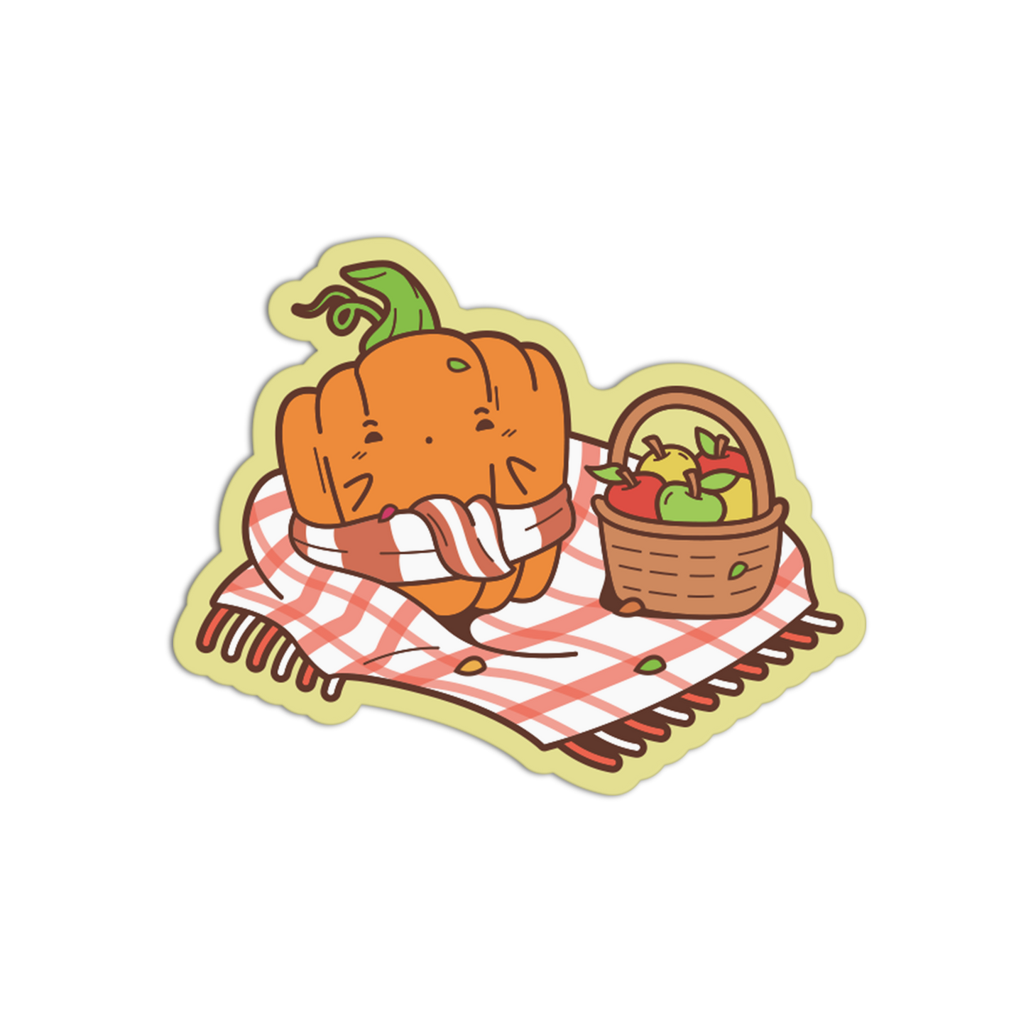 A die-cut sticker featuring a cute cartoon pumpkin wrapped in a red-and-white striped blanket next to a basket of apples, on a plain white background.