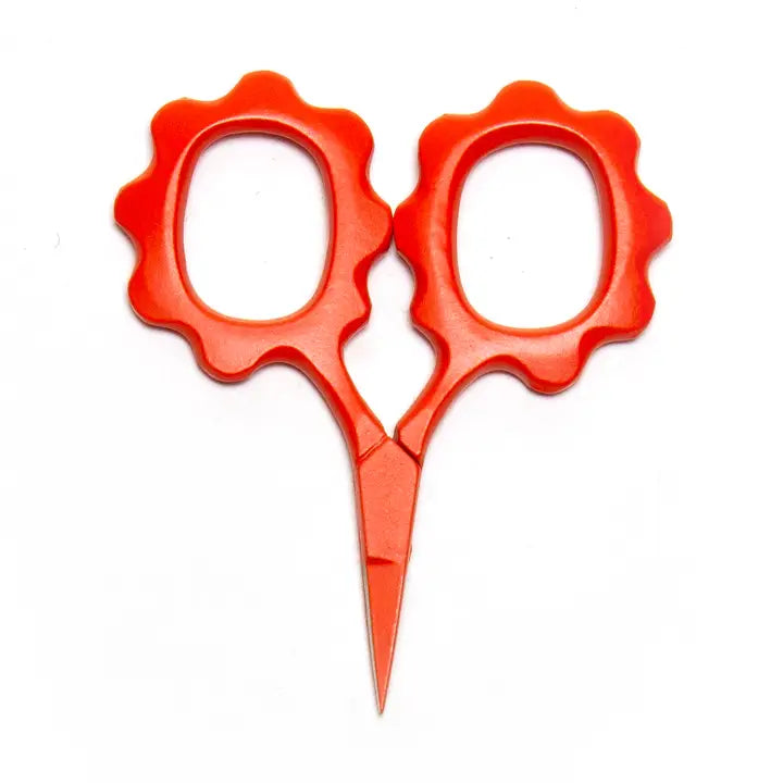 Red scissors with decorative handles on a white background