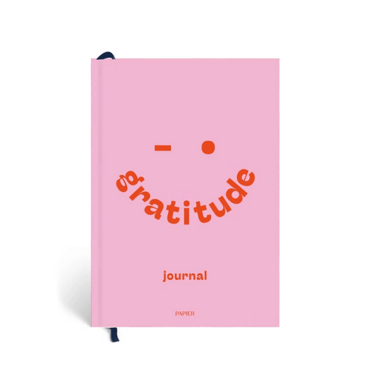 Pink journal with 'gratitude' text on a white background