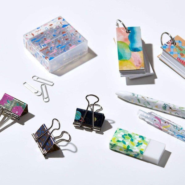Colorful stationery items including pens, clips, and sticky notes on a white background