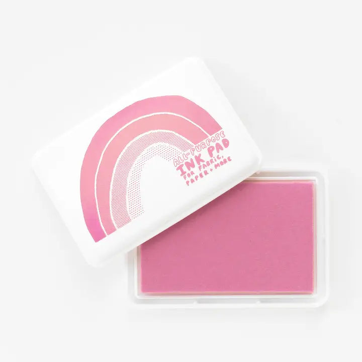 Pink ink pad with rainbow design and text on a white background