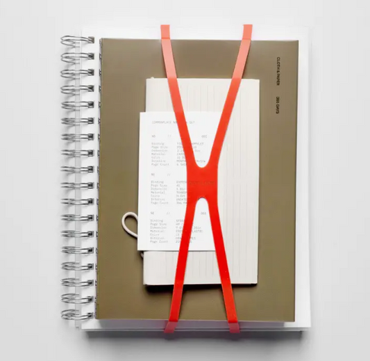 Notebook with a red elastic band on a white background