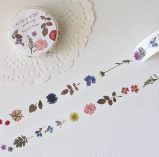 Roll of floral washi tape on a white surface with decorative doily