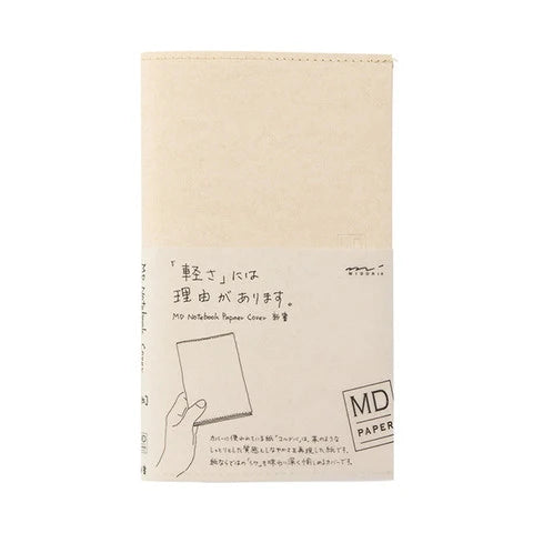 A beige notebook with Japanese text and a simple line drawing of a hand holding a square sheet of paper, shown on a plain white background. The cover includes the text 'MD PAPER'.