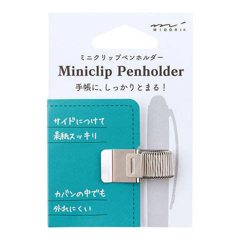 MIDORI miniclip penholder packaging with teal penholder and white pen on a light blue background