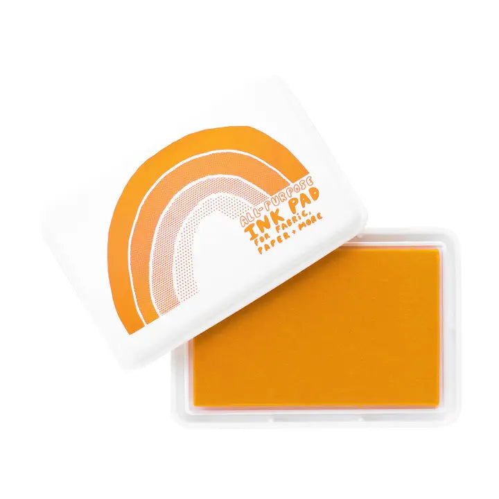 An open clear plastic TNK PAD ink pad case showing a bright orange ink pad, with the white lid leaning against it and printed with an orange rainbow design and the text 'Artist Potter TNK PAD THE CLASSIC INK PAD'.