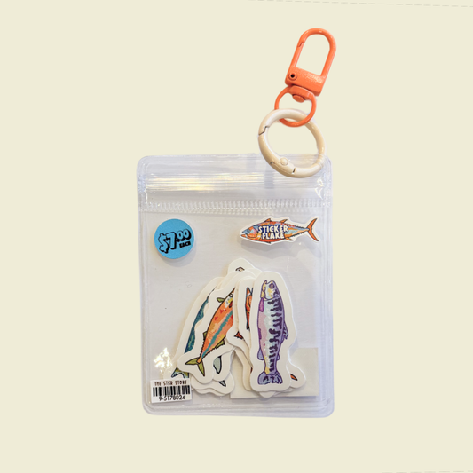 A clear plastic zippered pouch containing fish-shaped stickers, with an orange carabiner clip and white ring at the top, shown on a plain light beige background.
