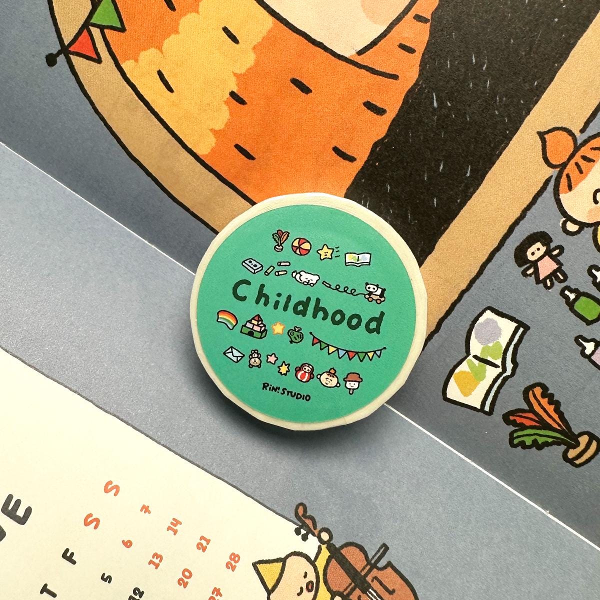 Green washi tape with 'Childhood' text and illustrations on a colorful background