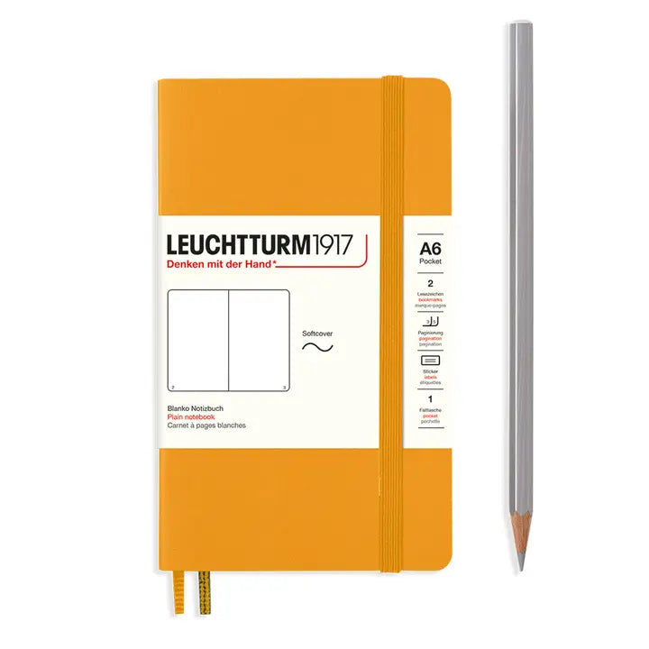 Orange notebook with white label and a pencil on a white background