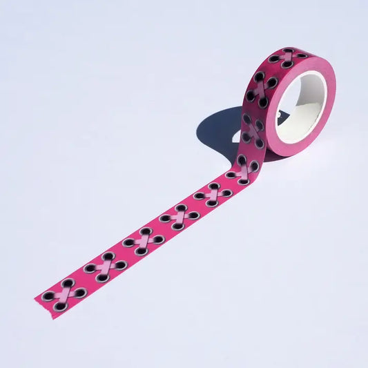 Pink tape with black dots on a light purple background