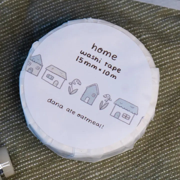 Washi tape roll with 'home' design and text on a textured surface