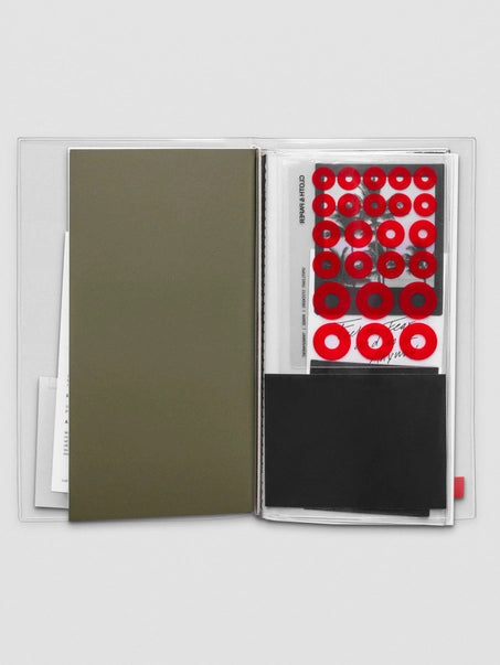 Set of stamps with red circular designs in a transparent holder on a white background
