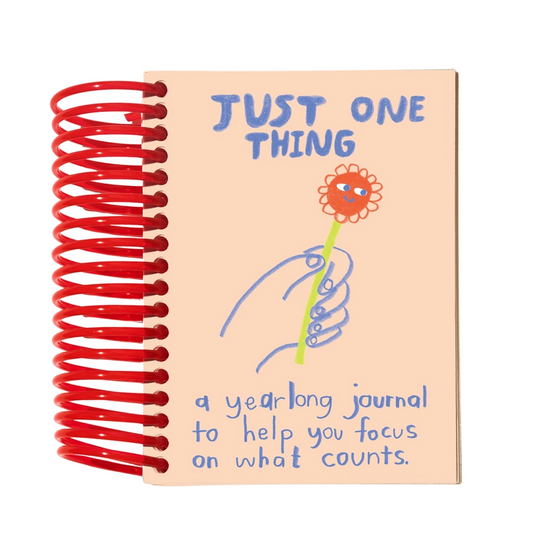 Notebook with red spiral binding and 'Just One Thing' cover design on a white background