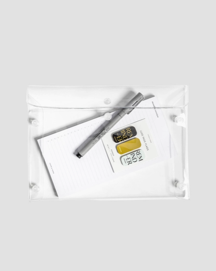 Two gold bars and a pen in a clear plastic bag on a white background