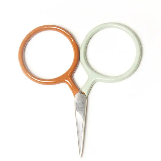Pair of small scissors with orange and white handles on a white background
