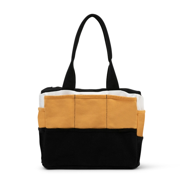 Tote bag with black, mustard yellow, and white color block design on a white background