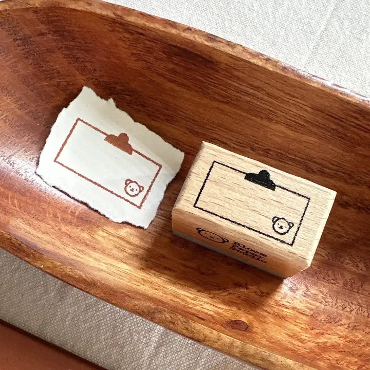 Wooden stamp and stamped paper on a wooden surface