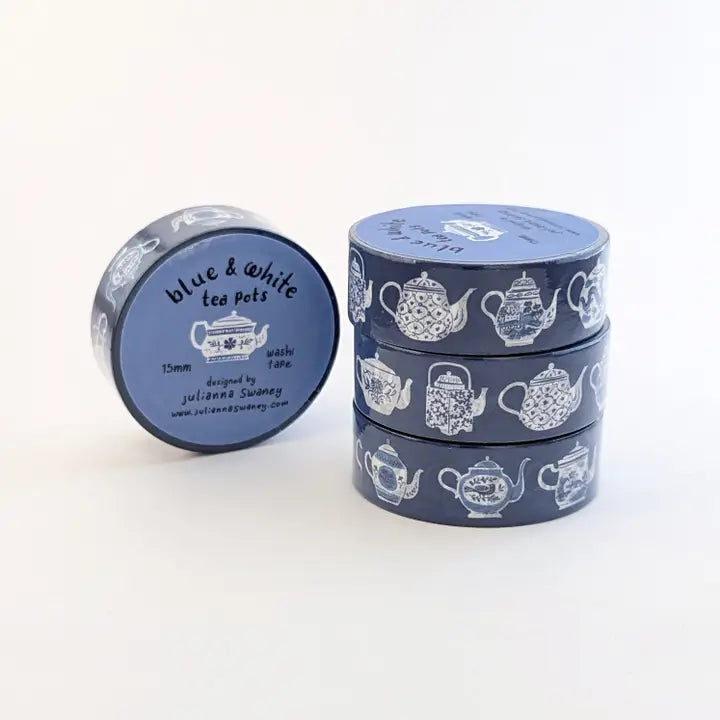 Set of blue and white tea pot-themed tins on a white background