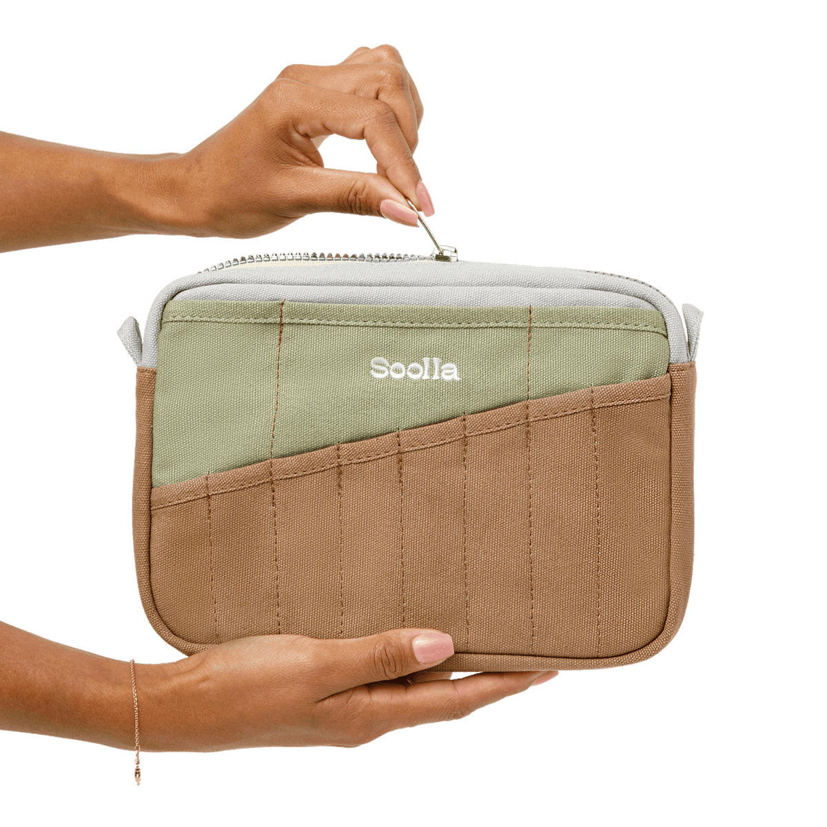 Person opening a green and brown travel pouch with 'Soolala' branding on a black background