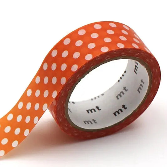 Roll of orange tape with white polka dots on a white background