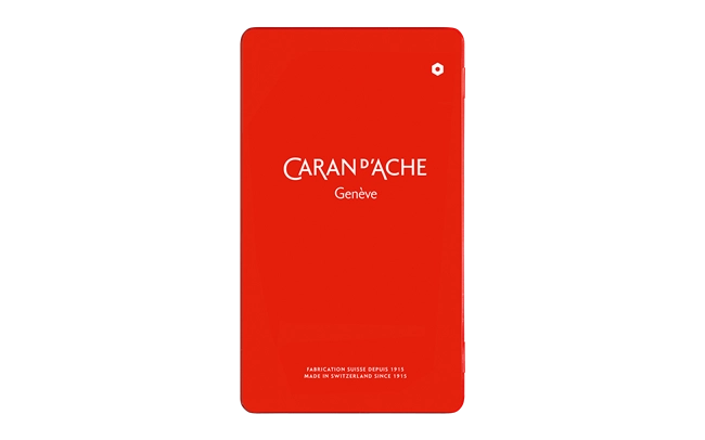 Red notebook with 'Caran d'Ache Geneve' branding on a white background