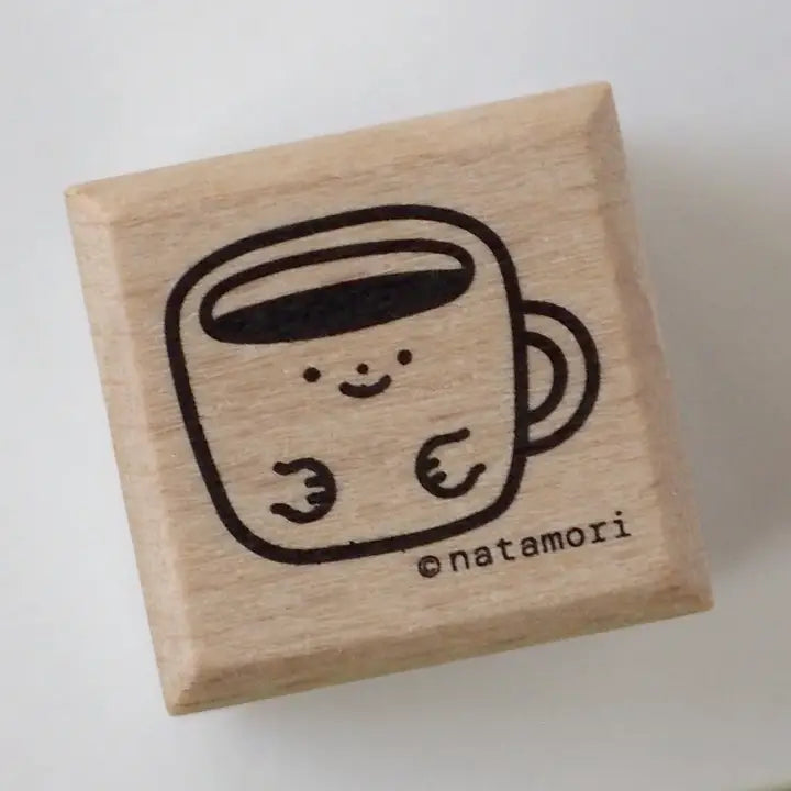 Wooden stamp with a cute coffee cup design and 'natamori' branding on a white background