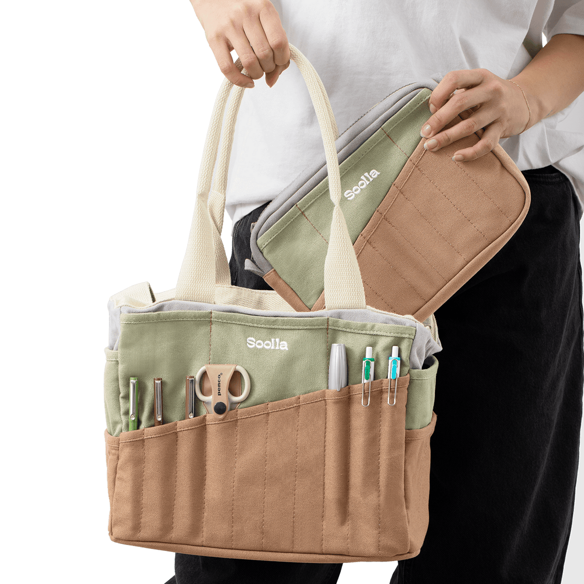 Person holding a beige and green bag with multiple compartments and tools.