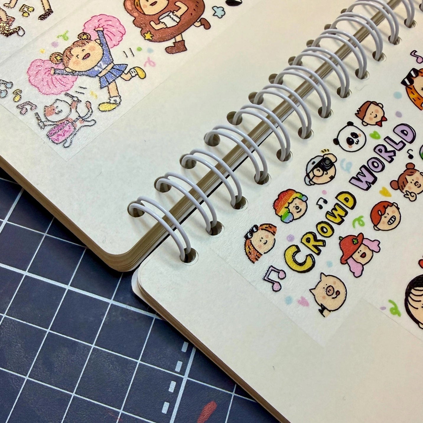 Notebook with cartoon character illustrations on a grid background