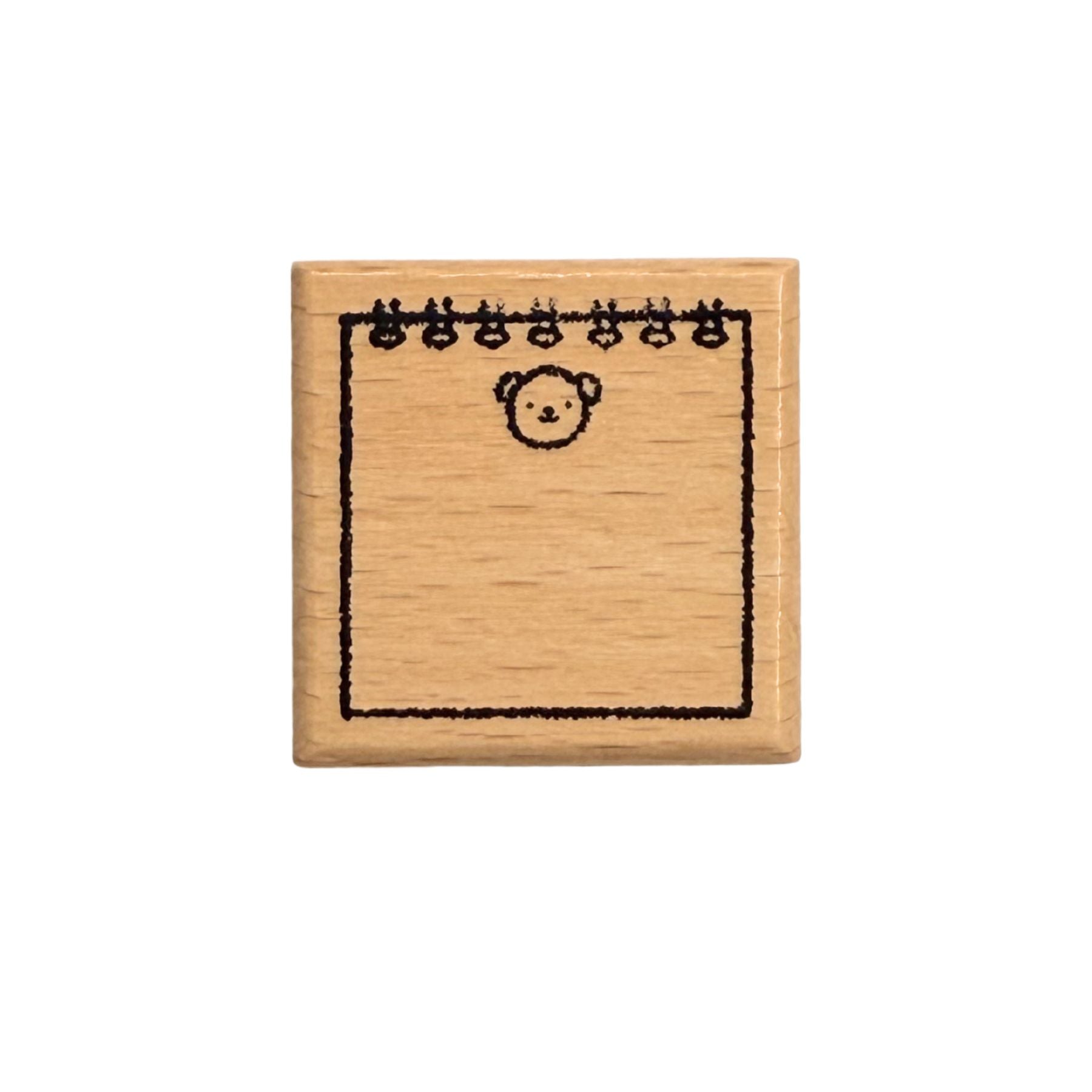Small wooden stamp with a bear design on a white background