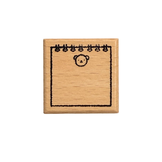 Small wooden stamp with a bear design on a white background