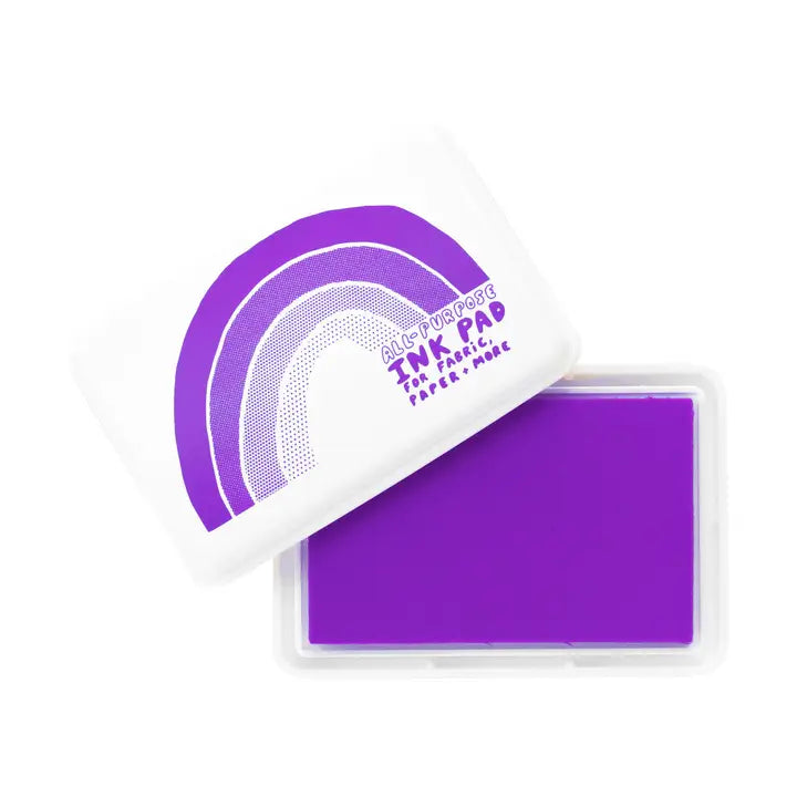 A purple TNK paper ink pad in a clear plastic case with its white lid resting on top, featuring a purple rainbow graphic and the text 'Magic Powder TNK PAD'.