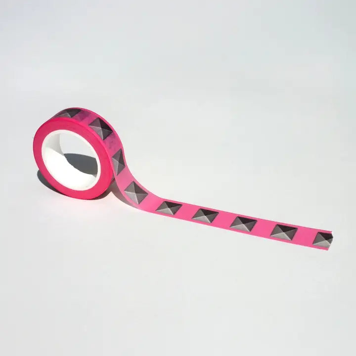 Roll of pink tape with black diamond pattern on a light gray background