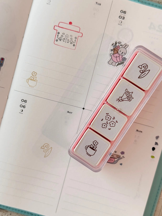 Set of small square stamps with cute designs on a planner page.