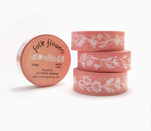 Set of pink washi tape rolls with floral designs on a white background