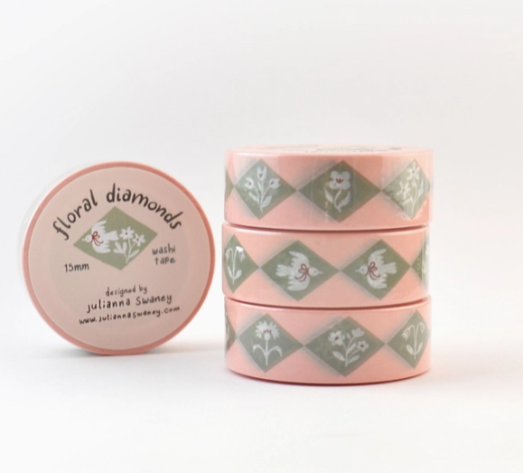 Stack of pink washi tape with green diamond pattern on a white background