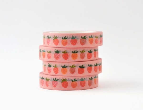 Stack of pink washi tape with fruit pattern on a white background