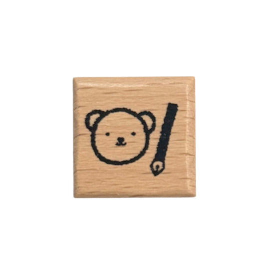 Square wooden stamp with bear face and pencil design on a white background