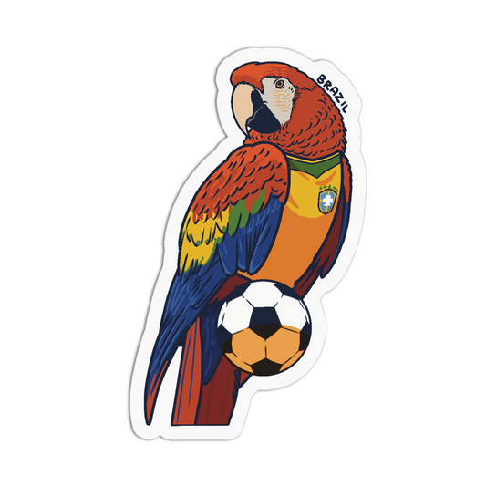 A die-cut sticker featuring a colorful parrot wearing a Brazil soccer jersey and holding a soccer ball, with the word 'BRAZIL' printed above the bird, shown on a plain white background.