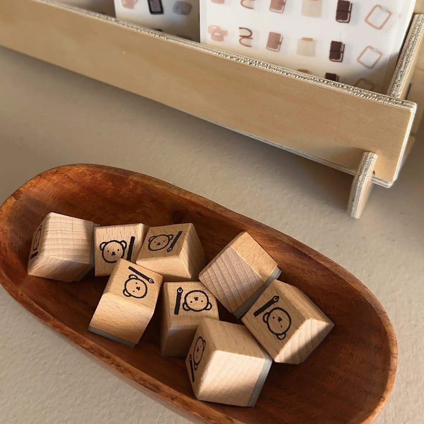 Wooden blocks with icons in a wooden bowl on a light surface