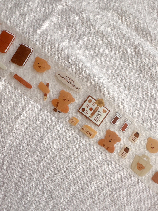 Decorative washi tape with cartoon bear design on a textured white background