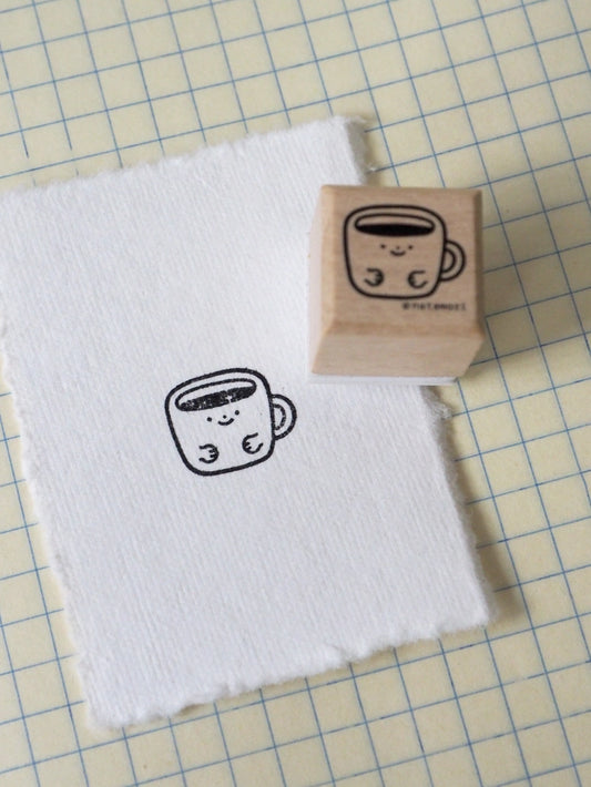 Wooden stamp with a cute cup design on a white towel