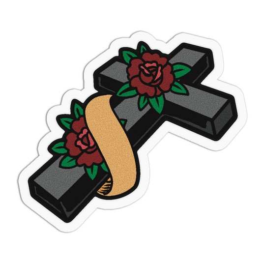 A die-cut sticker featuring a black cross decorated with two red roses with green leaves and a gold ribbon, shown on a plain white background.